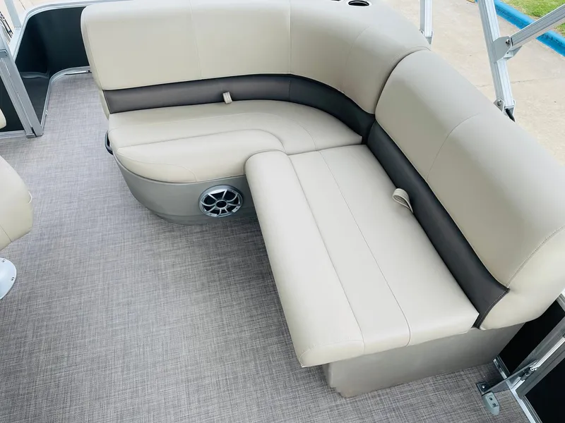 Slide: The Image of 2025 Sun Tracker Party Barge 18 DLX interior seating with beige upholstery and speaker. - 18