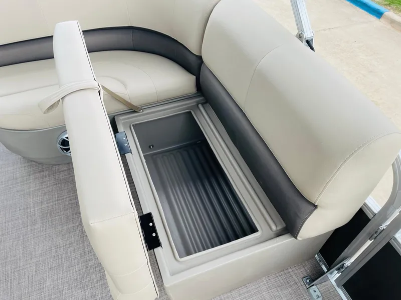 Slide: The Image of 2025 Sun Tracker Party Barge 18 DLX storage compartment with beige seating. - 19