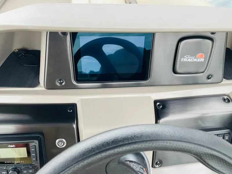 Slide: The Image of 2025 Sun Tracker Party Barge 18 DLX dashboard with steering wheel and control panel. - 23