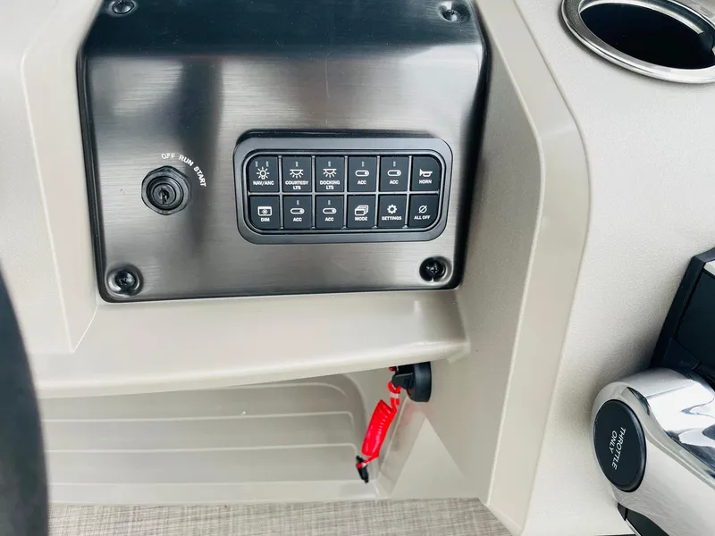 Slide: The Image of Control panel of 2025 Sun Tracker Party Barge 18 DLX with switches and cup holder. - 24