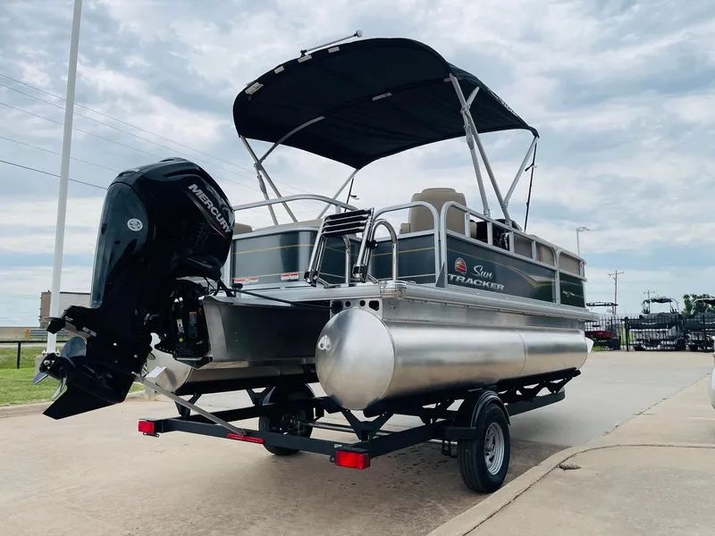 Slide: The Image of 2025 Sun Tracker Party Barge 18 DLX pontoon boat on trailer, outdoor view. - 5