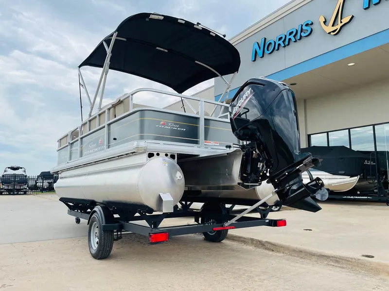 Slide: The Image of 2025 Sun Tracker Party Barge 18 DLX pontoon boat on trailer at dealership. - 7