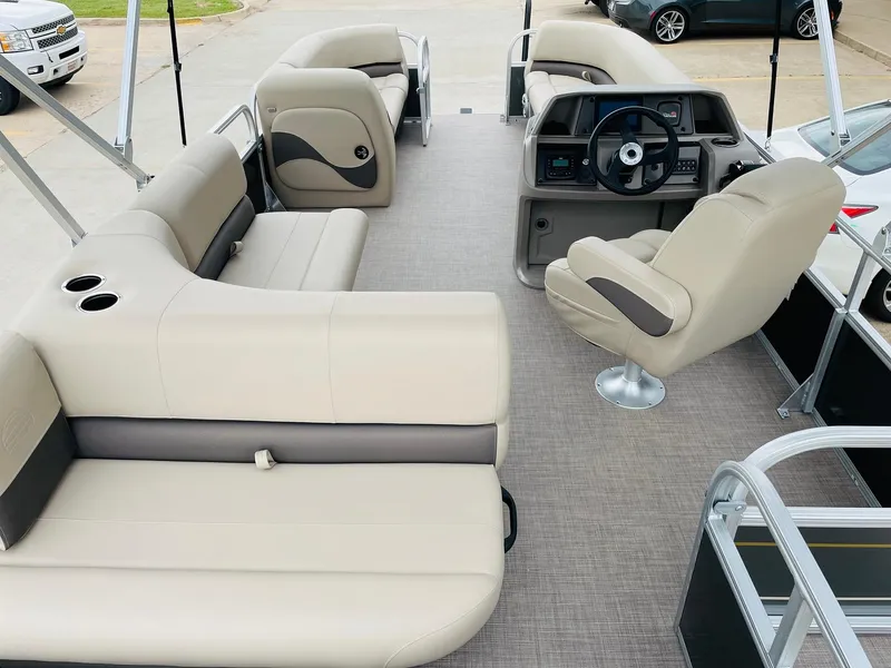 Slide: The Image of 2025 Sun Tracker Party Barge 18 DLX interior with beige seating and steering console. - 8