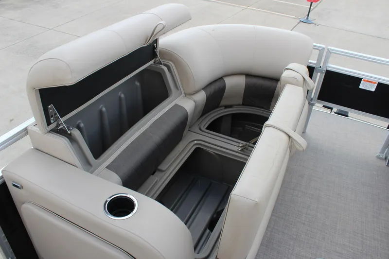 Slide: The Image of 2025 Sun Tracker SportFish 22 DLX boat interior with open storage compartments and cup holder. - 15