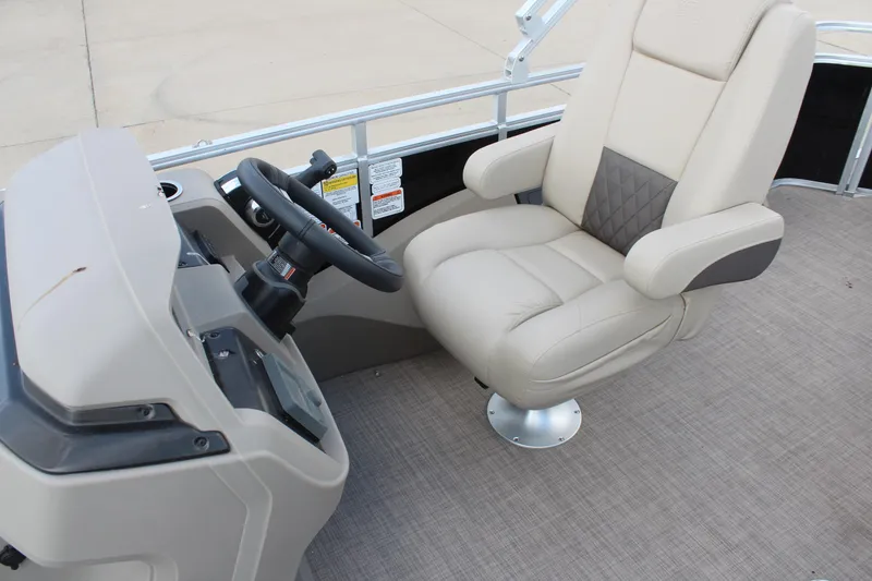 Slide: The Image of 2025 Sun Tracker SportFish 22 DLX boat interior with beige captain's chair and steering console. - 17