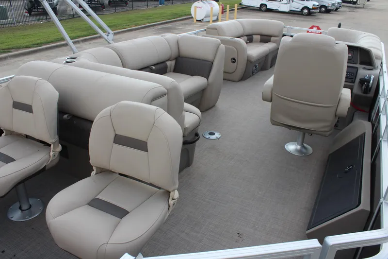 Slide: The Image of 2025 Sun Tracker SportFish 22 DLX pontoon boat interior with beige seating and spacious layout. - 23