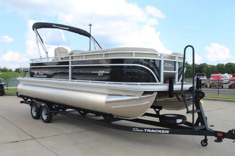 Slide: The Image of 2025 Sun Tracker SportFish 22 DLX pontoon boat on trailer, parked outdoors. - 3