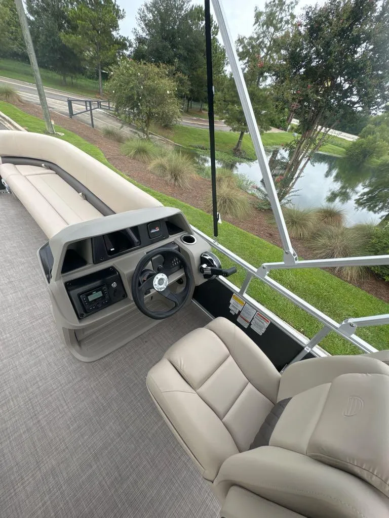 Slide: The Image of 2025 Sun Tracker Party Barge 18 DLX interior with steering wheel and seating. - 6