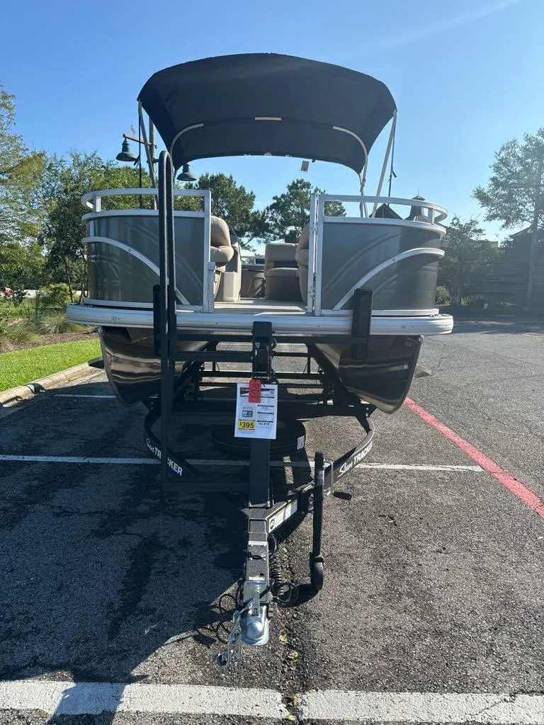 Slide: The Image of 2025 Sun Tracker Fishin' Barge 20 DLX pontoon boat on trailer in parking lot. - 3
