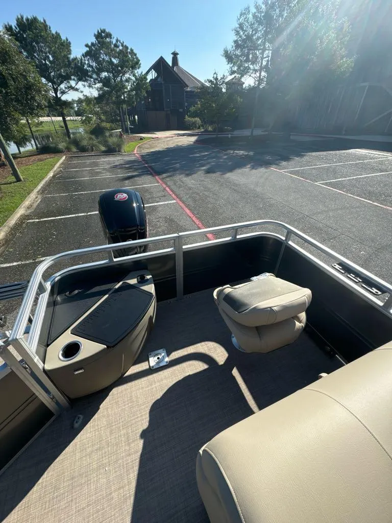 Slide: The Image of 2025 Sun Tracker Fishin' Barge 20 DLX pontoon boat in parking lot, sunny day. - 4