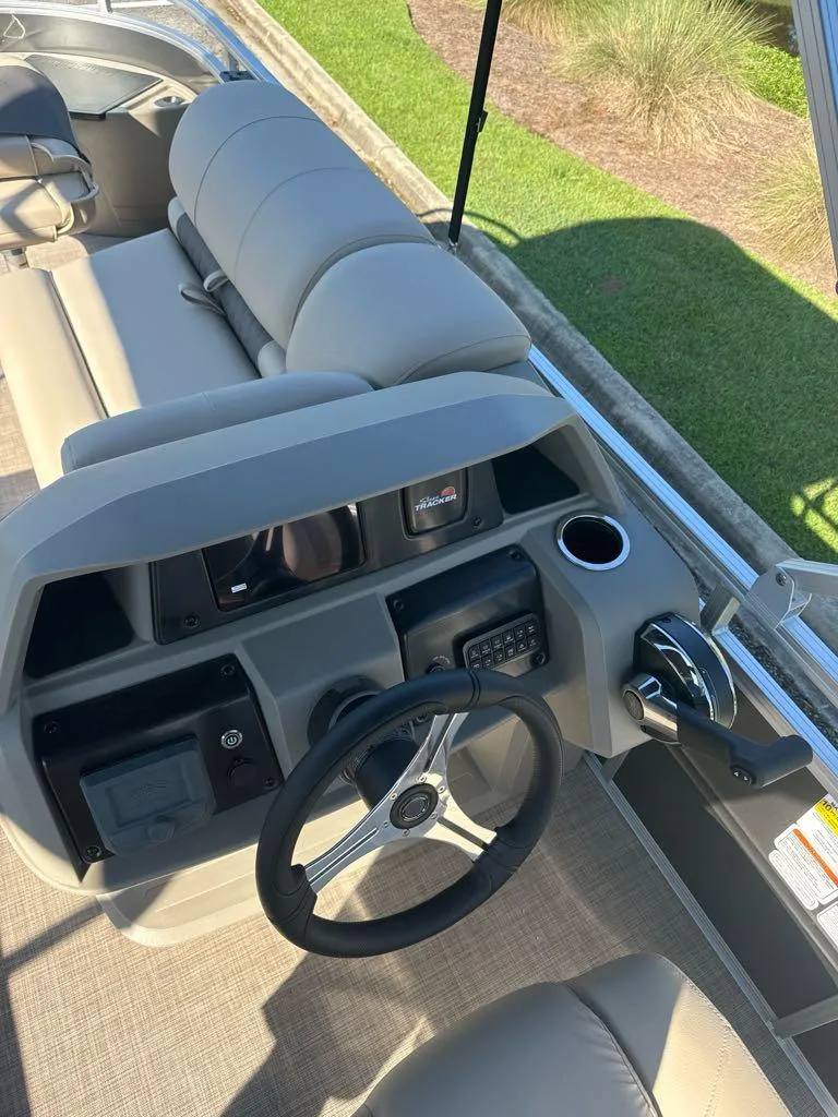 Slide: The Image of 2025 Sun Tracker Fishin' Barge 20 DLX helm with steering wheel and controls. - 7