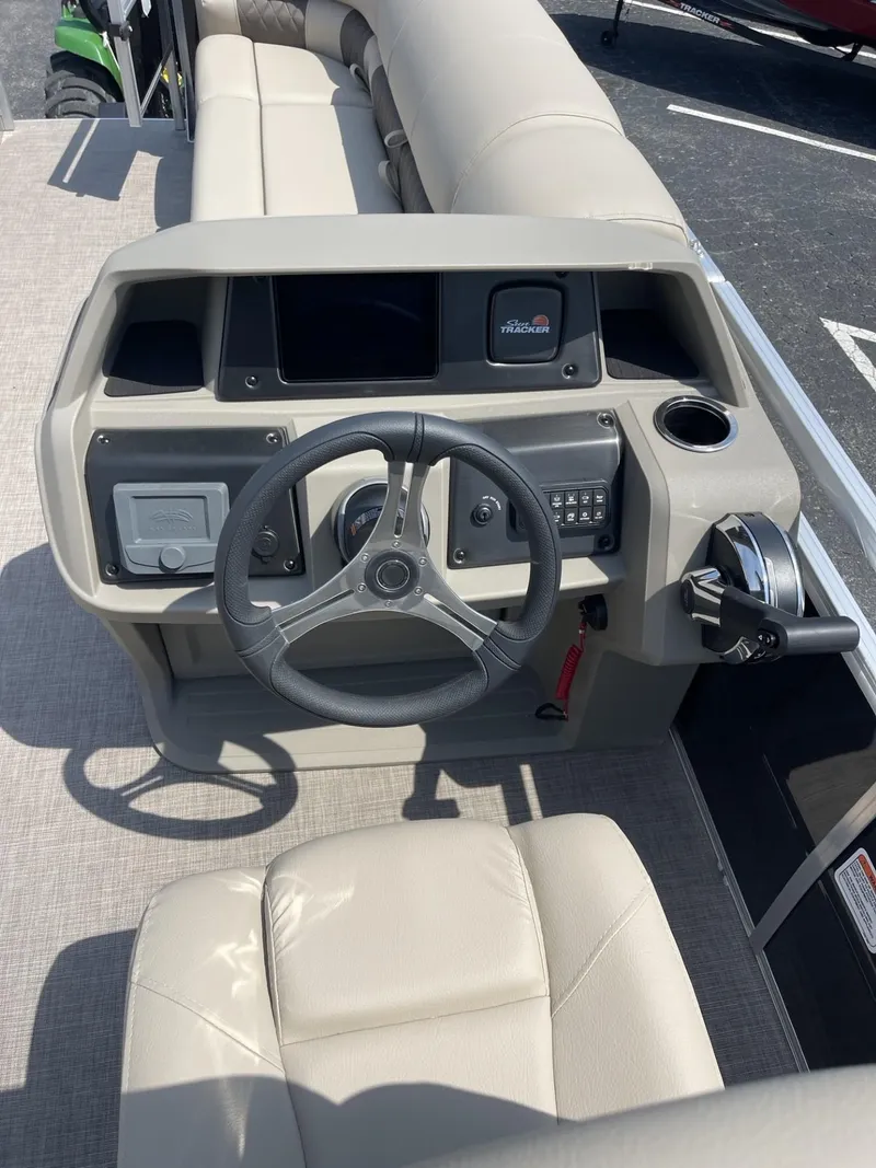 Slide: The Image of 2025 Sun Tracker SportFish 20 DLX boat console with steering wheel and controls. - 12