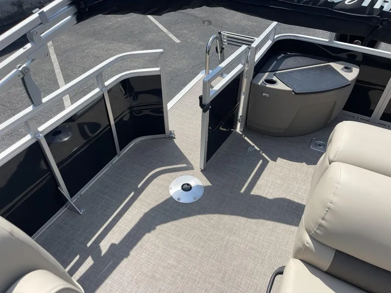 Slide: The Image of 2025 Sun Tracker SportFish 20 DLX pontoon boat interior with beige seating and open gate. - 9
