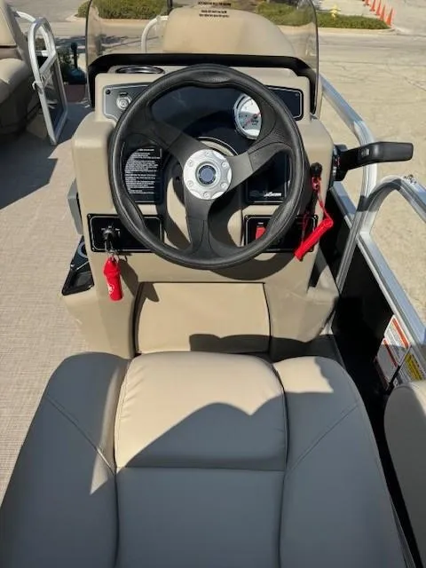Slide: The Image of 2025 Sun Tracker Party Barge 16 DLX steering console with beige seating. - 3