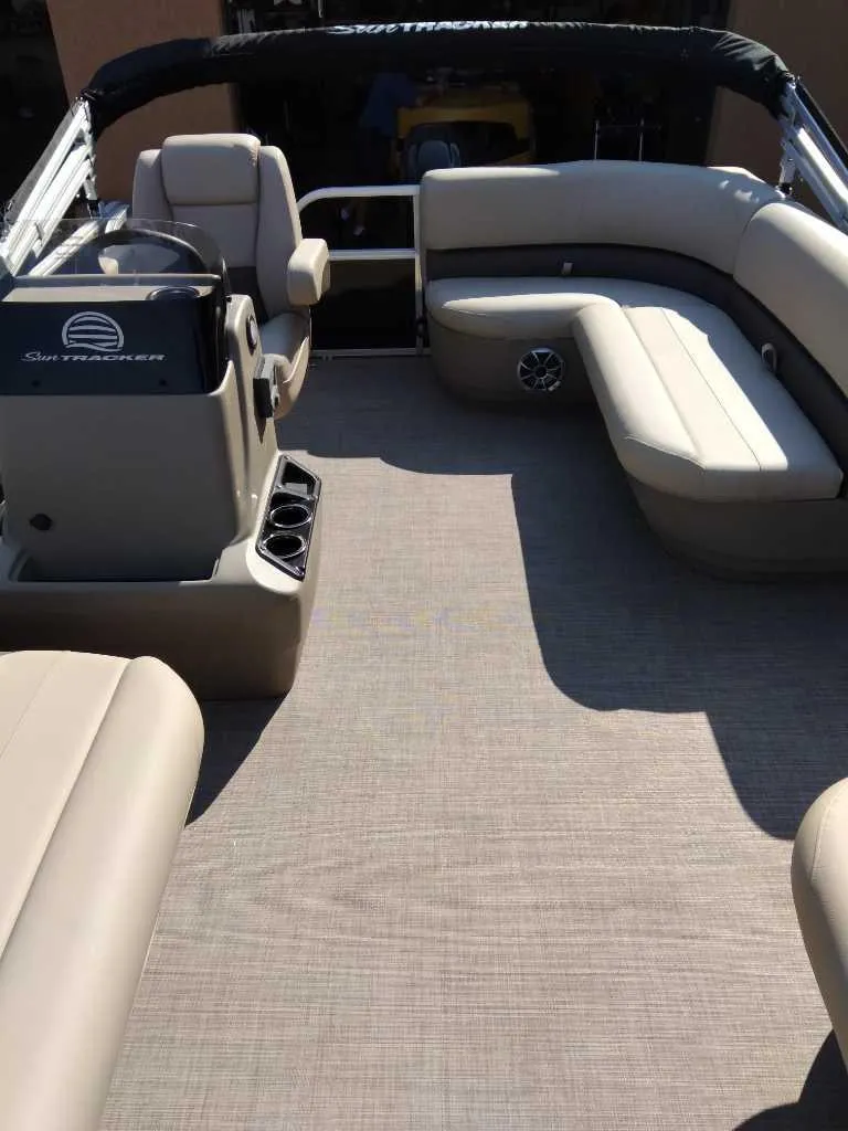 Slide: The Image of 2025 Sun Tracker Party Barge 16 DLX interior with beige seating and spacious layout. - 4
