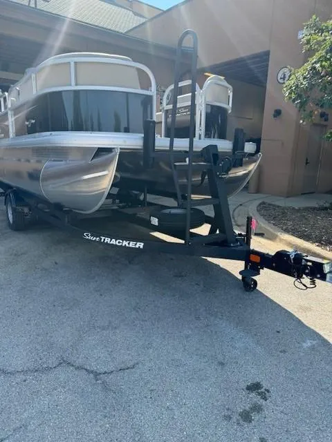 Slide: The Image of 2025 Sun Tracker Party Barge 16 DLX pontoon boat on trailer in parking lot. - 7