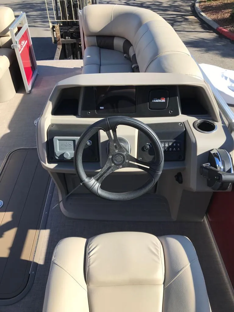 Slide: The Image of 2025 Sun Tracker Party Barge 22 RF XP3 boat interior with steering wheel and seating. - 9