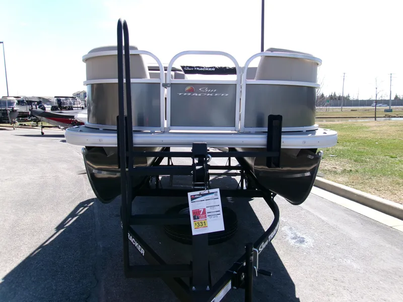 Slide: The Image of 2025 Sun Tracker Party Barge 18 DLX pontoon boat on trailer in parking lot. - 3
