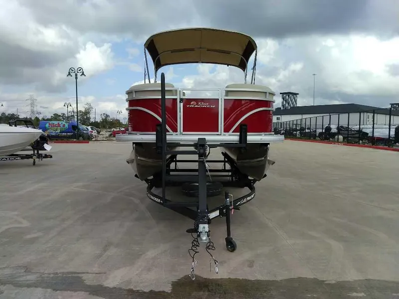Slide: The Image of 2025 Sun Tracker Party Barge 20 DLX pontoon boat on trailer, outdoor display. - 2