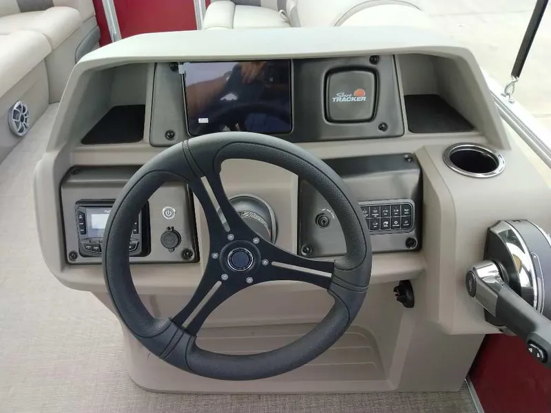 Slide: The Image of 2025 Sun Tracker Party Barge 20 DLX steering console with controls and cup holder. - 6
