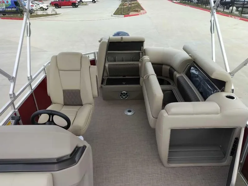 Slide: The Image of 2025 Sun Tracker Party Barge 20 DLX interior with beige seating and steering wheel. - 7