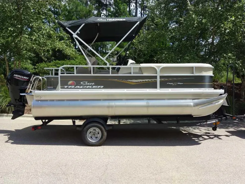The Image of 2025 Sun Tracker Party Barge 18 DLX pontoon boat on trailer, parked outdoors. - 0