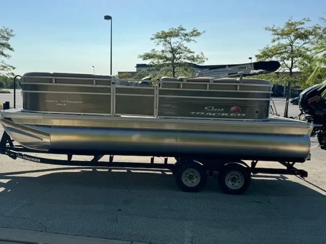 Slide: The Image of 2025 Sun Tracker Party Barge 20 DLX pontoon boat on trailer in parking lot. - 6