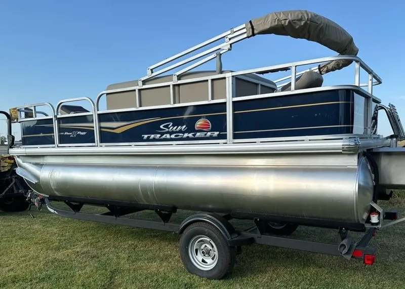Slide: The Image of 2025 Sun Tracker Bass Buggy 18 DLX pontoon boat on trailer, side view. - 3