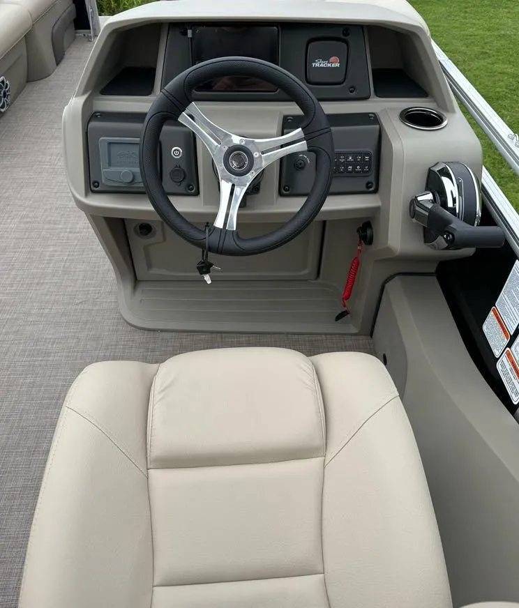 Slide: The Image of 2025 Sun Tracker SportFish 22 DLX boat helm with steering wheel and controls. - 7