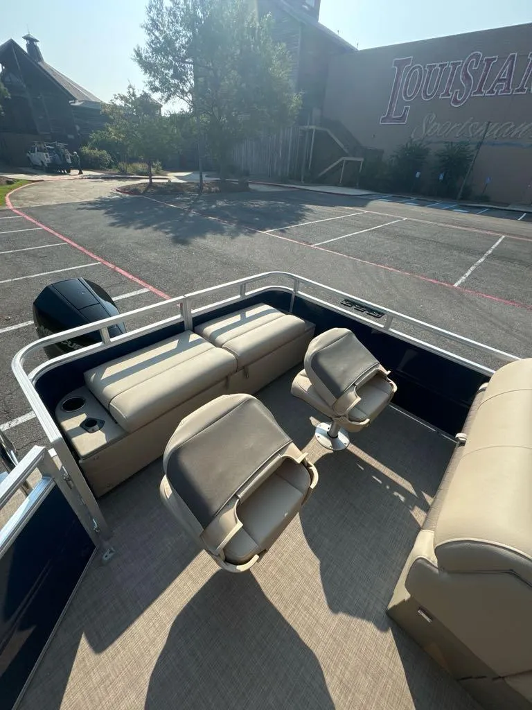 Slide: The Image of 2025 Sun Tracker Fishin' Barge 22 XP3 pontoon boat with seating, parked outdoors. - 6