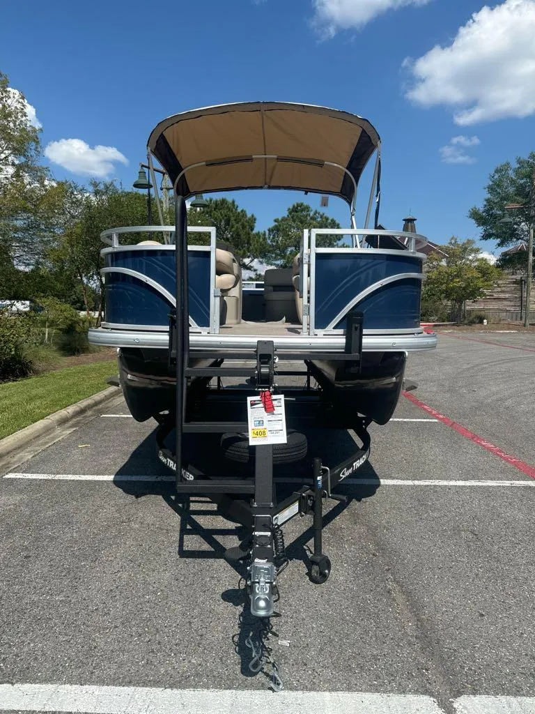 Slide: The Image of 2025 Sun Tracker Fishin' Barge 20 DLX pontoon boat on trailer in parking lot. - 3