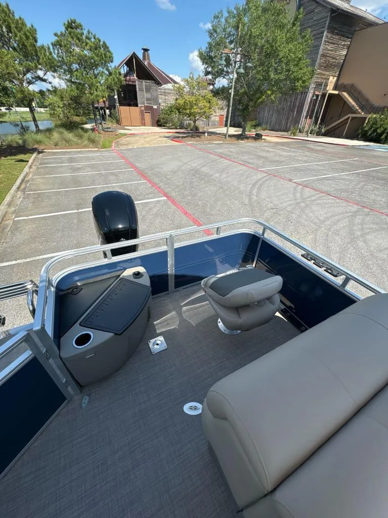Slide: The Image of 2025 Sun Tracker Fishin' Barge 20 DLX in parking lot, showcasing seating and deck. - 6