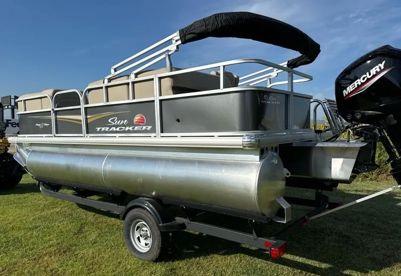 Slide: The Image of 2025 Sun Tracker Party Barge 18 DLX pontoon boat on trailer, featuring Mercury outboard motor. - 3