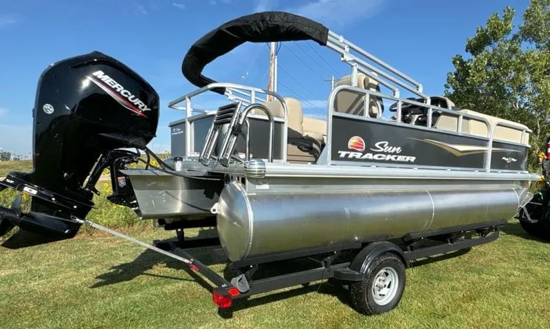 Slide: The Image of 2025 Sun Tracker Party Barge 18 DLX pontoon boat with Mercury engine on grass. - 6