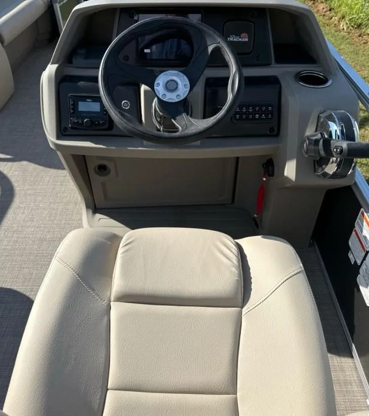 Slide: The Image of 2025 Sun Tracker Party Barge 18 DLX steering console with beige seating. - 8