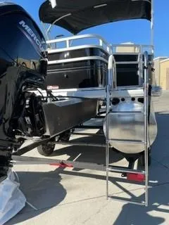 Slide: The Image of 2025 Sun Tracker SportFish 20 DLX pontoon boat with Mercury engine and ladder. - 2