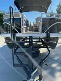 Slide: The Image of 2025 Sun Tracker SportFish 20 DLX pontoon boat on trailer, front view. - 3