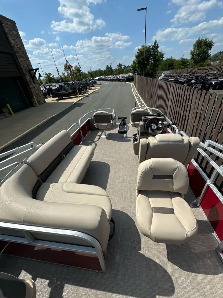 Slide: The Image of 2025 Sun Tracker Bass Buggy 18 DLX pontoon boat with beige seating and steering console. - 3