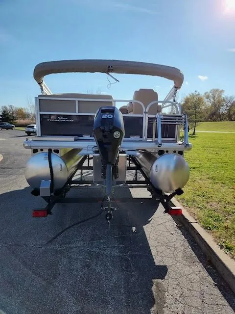 Slide: The Image of 2025 Sun Tracker Bass Buggy 16 XL Select pontoon boat, rear view in a sunny parking lot. - 3