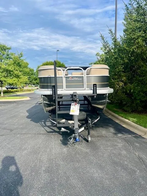 Slide: The Image of 2025 Sun Tracker Party Barge 18 DLX pontoon boat on trailer in parking lot. - 2