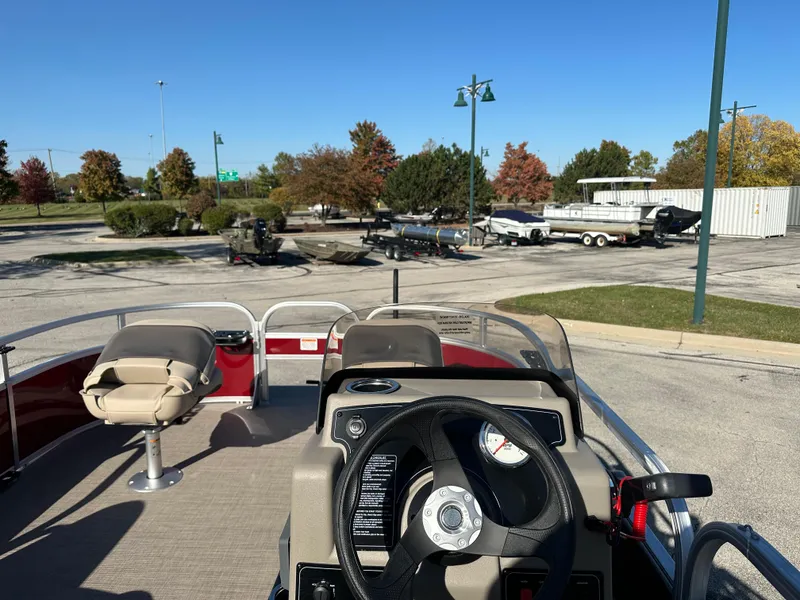 Slide: The Image of 2025 Sun Tracker Bass Buggy 16 XL Select pontoon boat in parking lot. - 4