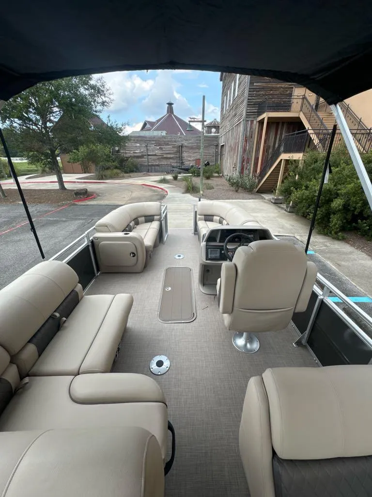 Slide: The Image of 2025 Sun Tracker Party Barge 22 RF XP3 interior with beige seating and steering console. - 5