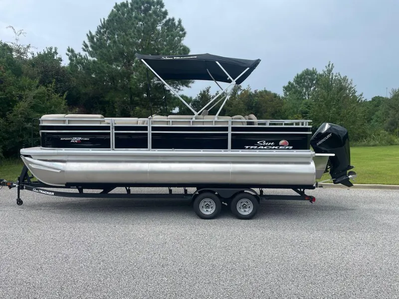 The Image of 2025 Sun Tracker SportFish 22 XP3 pontoon boat on trailer, parked outdoors. - 0
