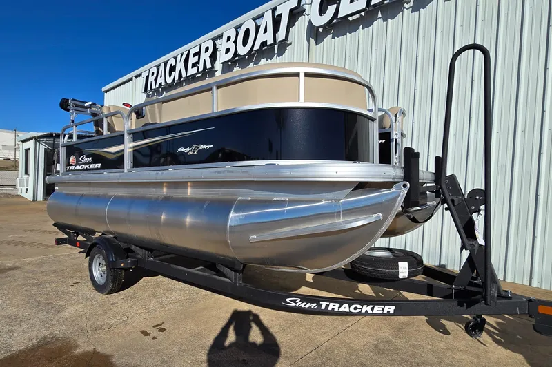 Slide: The Image of 2025 Sun Tracker Party Barge 16 DLX pontoon boat on trailer at dealership. - 2