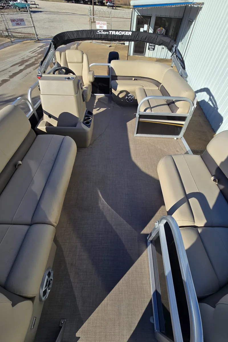 Slide: The Image of 2025 Sun Tracker Party Barge 16 DLX interior with beige seating and spacious layout. - 5