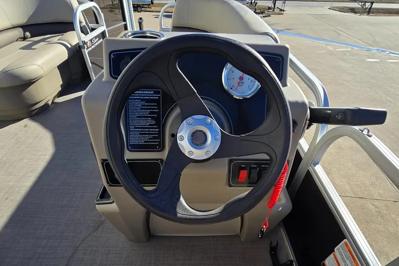 Slide: The Image of 2025 Sun Tracker Party Barge 16 DLX steering console with controls and seating. - 7