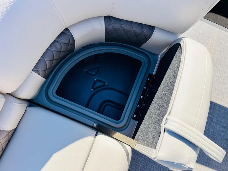 Slide: The Image of 2025 Sun Tracker SportFish 22 XP3 boat seat storage compartment, open with visible interior. - 19