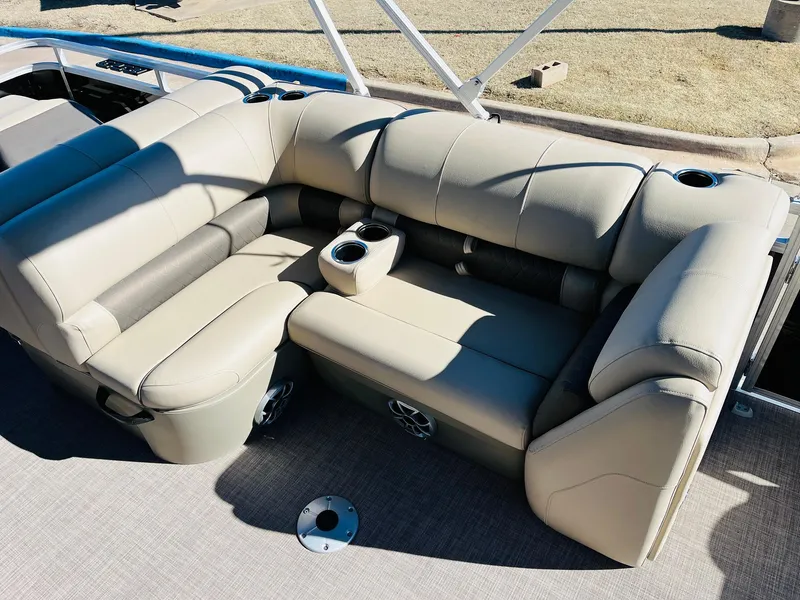 Slide: The Image of 2025 Sun Tracker SportFish 22 XP3 boat seating with beige upholstery and cup holders. - 33