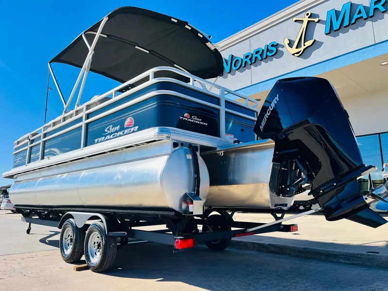 Slide: The Image of 2025 Sun Tracker SportFish 22 XP3 pontoon boat with outboard motor at dealership. - 7