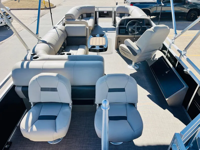 Slide: The Image of 2025 Sun Tracker SportFish 22 XP3 pontoon boat interior with plush seating and steering console. - 9